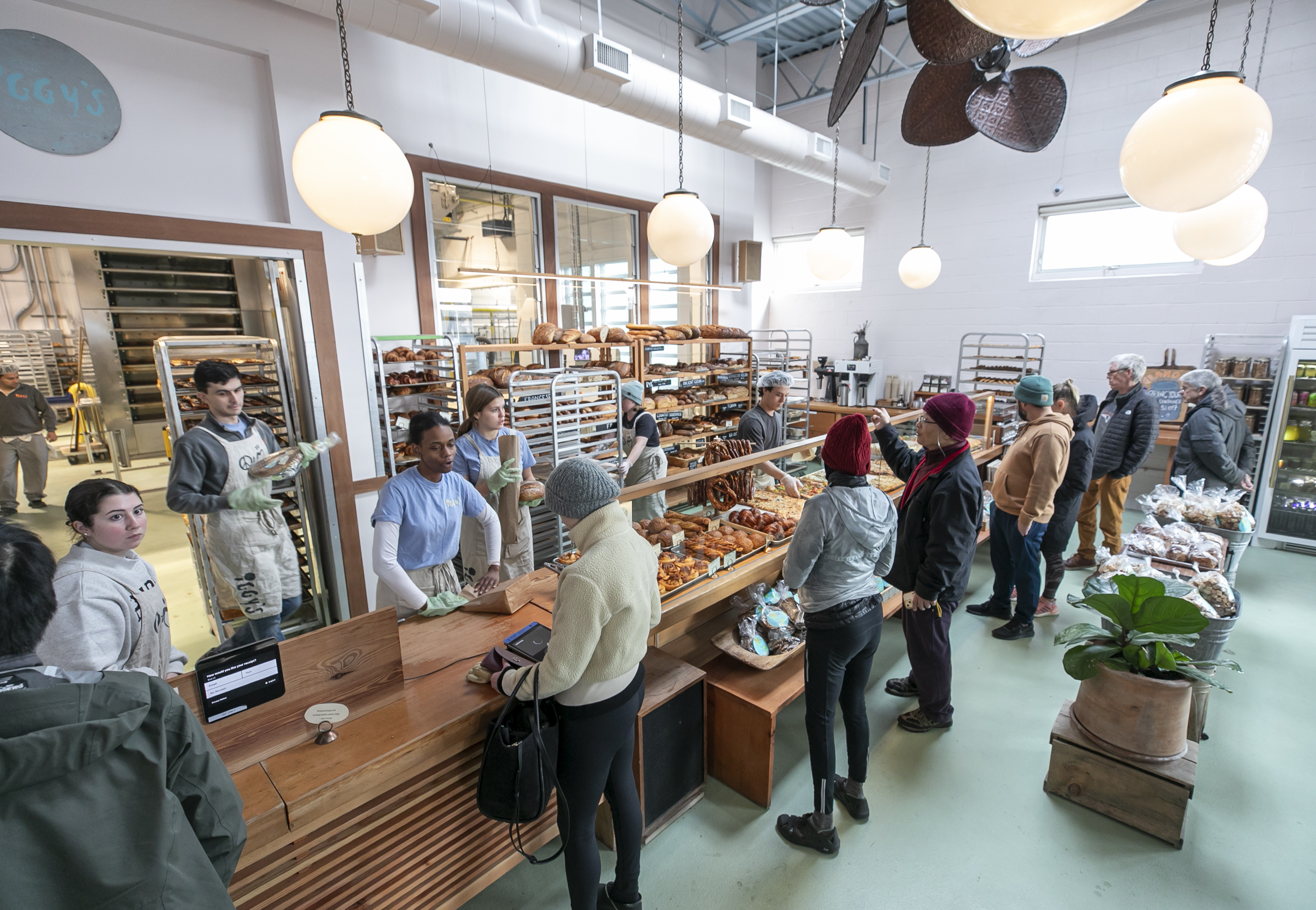 Picture of the ordering counter with people ordering bread at Iggy's Bread in Alewife.