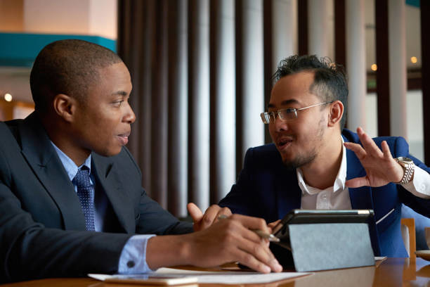 Image of two men holding a business meeting with a laptop between them
