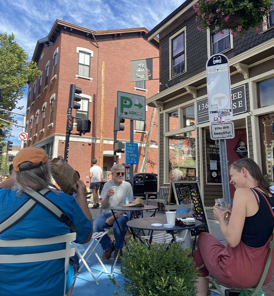 People sitting at cafe tables on Cambridge St