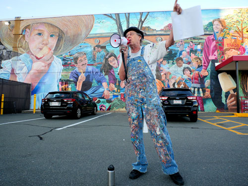 Artist David Fichter speaks about his mural “Sunday Afternoon on the Charles” on the Memorial Drive side of Trader Joe’s, July 2022.