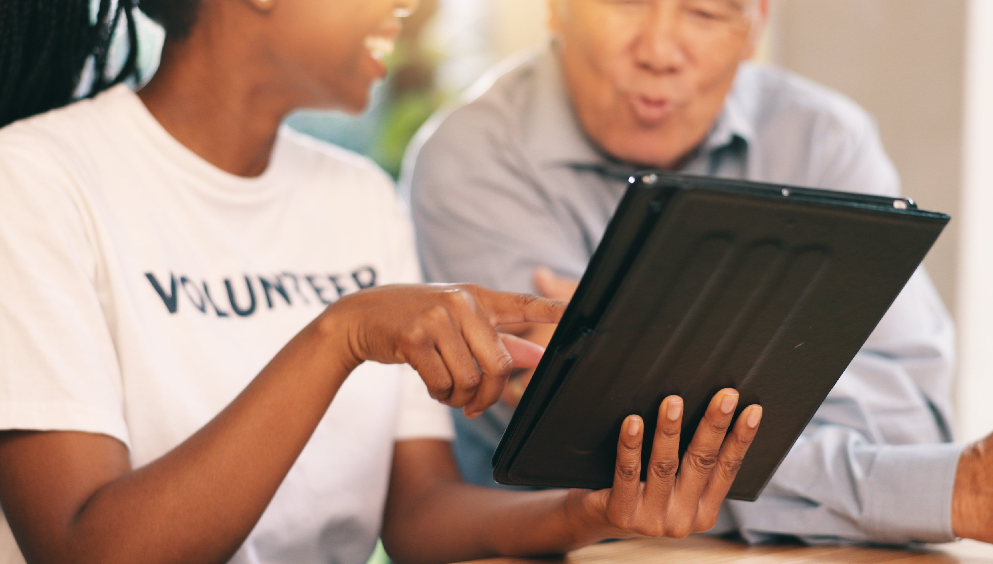 Young woman and older man looking at a tablet