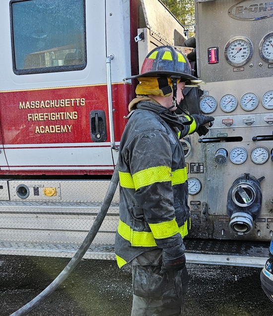 Cambridge recruit firefighter operating the pump at burn training - Mass Fire Academy