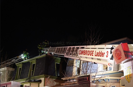 Ladders 1 and 3 with aerial ladders to the roof of the working fire Box 45-413 on Inman Street