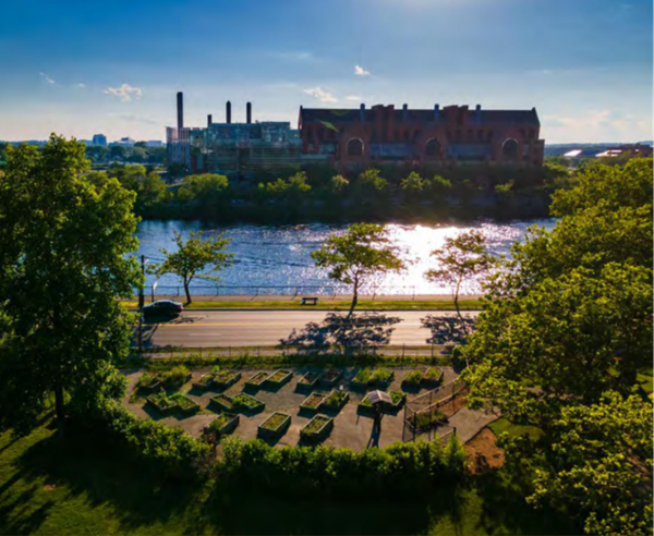 Aerial photo of the Riverside Press Park Garden with garden plots in the foreground, Charles river and the Boston side in the background.