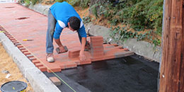 Photo of a worker repairing a sidewalk