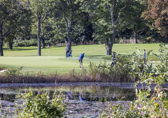 A golfer prepares to puts at Fresh Pond Golf Course