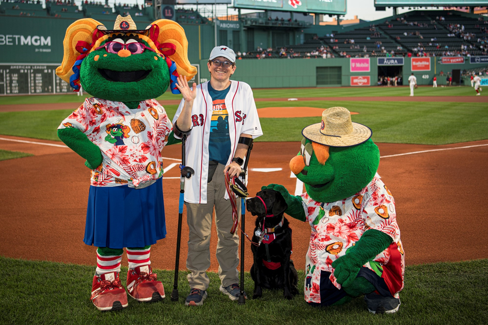 Kate Thurman with her newly matched NEADS World Class Service Dog, Pally, on the field at Fenway Park as Pally is honored as Service Dog of the Game on September 10.