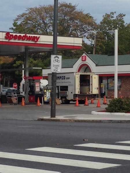 Small sign saying Share the Road in front of a gas station