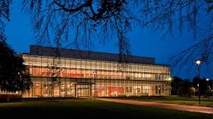 Front of Cambridge Public Library lit up as the sun sets