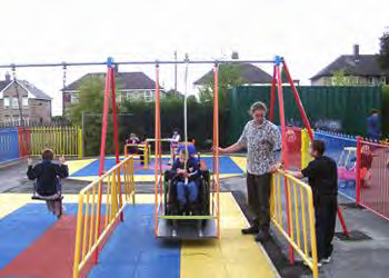 Kids playing on a swingset including one in a wheelchair