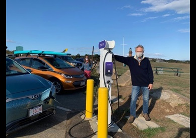 A pair of electric vehicles at a park plugged into EV chargers